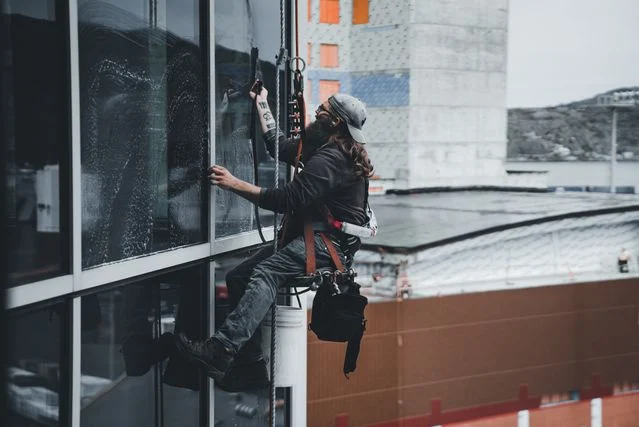 Janitor cleaning the windows of a building