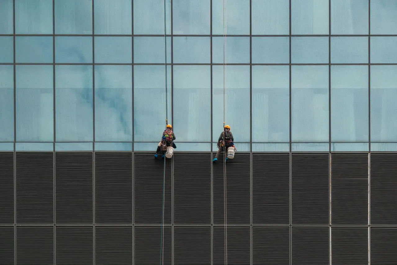 2 men cleaners washing the building windows